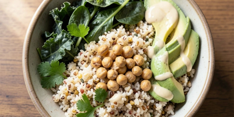 Quinoa-Bowl mit erkennbaren Komponenten: gekochtes Quinoa, dunkles Blattgemüse, geröstete Kichererbsen, Avocado – als Beispiel für eine pflanzliche Mahlzeit mit verschiedenen Nährstoffquellen